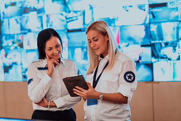 Image showing Group portrait of female security operator while working in a data system control room offices Technical Operator Working at workstation with multiple displays