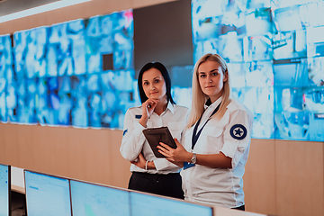 Image showing Group portrait of female security operator while working in a data system control room offices Technical Operator Working at workstation with multiple displays