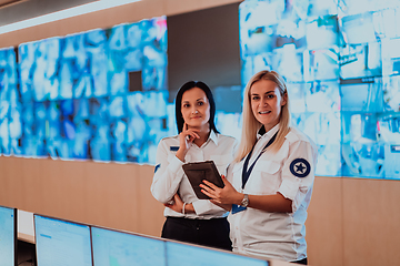 Image showing Group portrait of female security operator while working in a data system control room offices Technical Operator Working at workstation with multiple displays