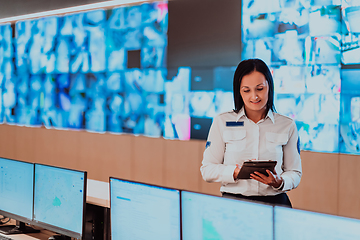 Image showing Female security operator working in a data system control room offices Technical Operator Working at workstation with multiple displays, security guard working on multiple monitors