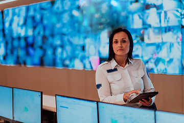 Image showing Female security operator working in a data system control room offices Technical Operator Working at workstation with multiple displays, security guard working on multiple monitors