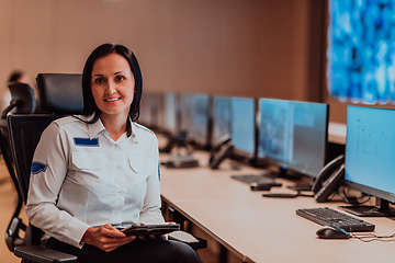 Image showing Female security operator working in a data system control room offices Technical Operator Working at workstation with multiple displays, security guard working on multiple monitors