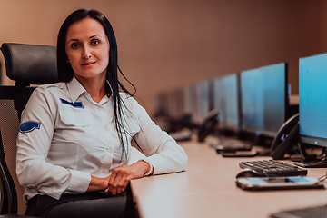 Image showing Female security operator working in a data system control room offices Technical Operator Working at workstation with multiple displays, security guard working on multiple monitors