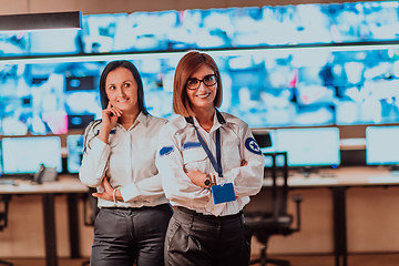 Image showing Group portrait of female security operator while working in a data system control room offices Technical Operator Working at workstation with multiple displays