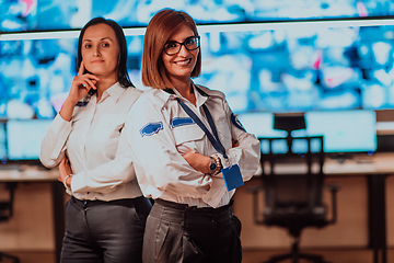 Image showing Group portrait of female security operator while working in a data system control room offices Technical Operator Working at workstation with multiple displays