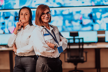 Image showing Group portrait of female security operator while working in a data system control room offices Technical Operator Working at workstation with multiple displays