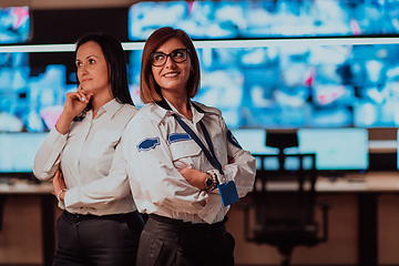 Image showing Group portrait of female security operator while working in a data system control room offices Technical Operator Working at workstation with multiple displays