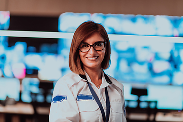 Image showing Female security operator working in a data system control room offices Technical Operator Working at workstation with multiple displays, security guard working on multiple monitors