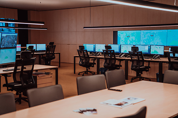 Image showing Empty interior of big modern security system control room, workstation with multiple displays, monitoring room with at security data center Empty office, desk, and chairs at a main CCTV security data