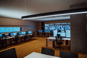 Image showing Empty interior of big modern security system control room, workstation with multiple displays, monitoring room with at security data center Empty office, desk, and chairs at a main CCTV security data