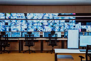 Image showing Empty interior of big modern security system control room, workstation with multiple displays, monitoring room with at security data center Empty office, desk, and chairs at a main CCTV security data