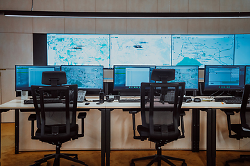 Image showing Empty interior of big modern security system control room, workstation with multiple displays, monitoring room with at security data center Empty office, desk, and chairs at a main CCTV security data