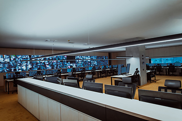 Image showing Empty interior of big modern security system control room, workstation with multiple displays, monitoring room with at security data center Empty office, desk, and chairs at a main CCTV security data