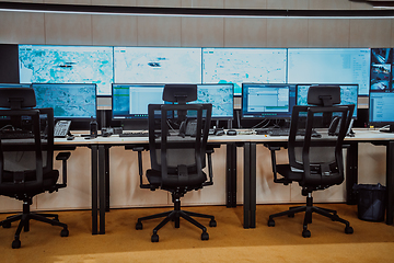 Image showing Empty interior of big modern security system control room, workstation with multiple displays, monitoring room with at security data center Empty office, desk, and chairs at a main CCTV security data