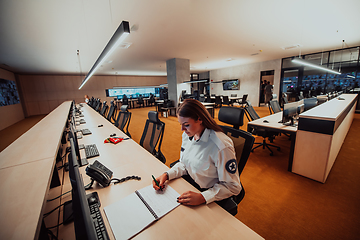 Image showing Female security operator working in a data system control room offices Technical Operator Working at workstation with multiple displays, security guard working on multiple monitors