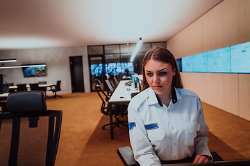 Image showing Female security operator working in a data system control room offices Technical Operator Working at workstation with multiple displays, security guard working on multiple monitors