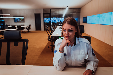 Image showing Female security operator working in a data system control room offices Technical Operator Working at workstation with multiple displays, security guard working on multiple monitors