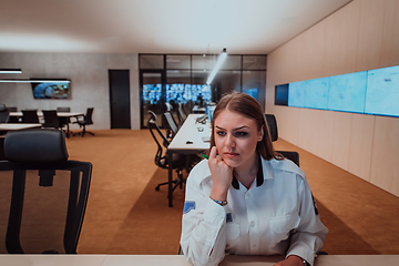 Image showing Female security operator working in a data system control room offices Technical Operator Working at workstation with multiple displays, security guard working on multiple monitors