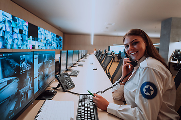 Image showing Female security operator working in a data system control room offices Technical Operator Working at workstation with multiple displays, security guard working on multiple monitors