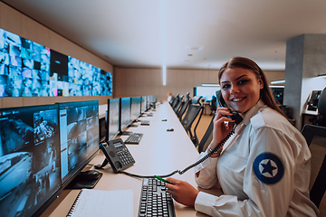 Image showing Female security operator working in a data system control room offices Technical Operator Working at workstation with multiple displays, security guard working on multiple monitors