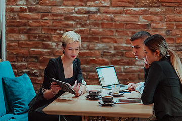 Image showing Happy businesspeople smiling cheerfully during a meeting in a coffee shop. Group of successful business professionals working as a team in a multicultural workplace.