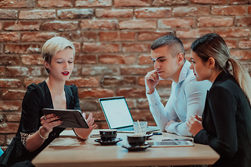 Image showing Happy businesspeople smiling cheerfully during a meeting in a coffee shop. Group of successful business professionals working as a team in a multicultural workplace.