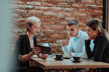 Image showing Happy businesspeople smiling cheerfully during a meeting in a coffee shop. Group of successful business professionals working as a team in a multicultural workplace.