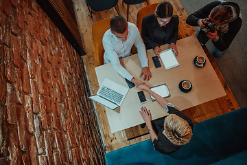 Image showing Top view photo of business shaking hands, finishing up meeting. Successful businesspeople handshaking after good deal