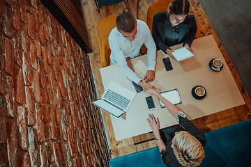 Image showing Top view photo of business shaking hands, finishing up meeting. Successful businesspeople handshaking after good deal