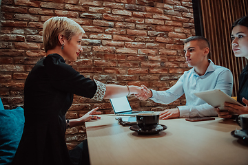 Image showing Business shaking hands, finishing up meeting. Successful businesspeople handshaking after good deal