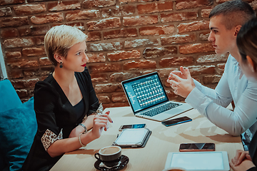 Image showing Happy businesspeople smiling cheerfully during a meeting in a coffee shop. Group of successful business professionals working as a team in a multicultural workplace.