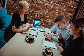 Image showing Happy businesspeople smiling cheerfully during a meeting in a coffee shop. Group of successful business professionals working as a team in a multicultural workplace.