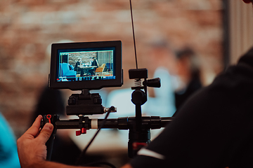 Image showing Behinde The Scenes. A cameraman records a business meeting that is streamed on TV channels