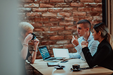 Image showing Happy businesspeople smiling cheerfully during a meeting in a coffee shop. Group of successful business professionals working as a team in a multicultural workplace.