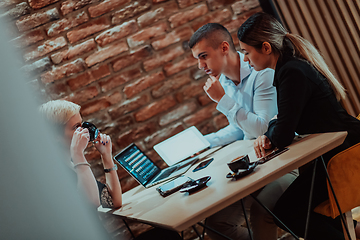 Image showing Happy businesspeople smiling cheerfully during a meeting in a coffee shop. Group of successful business professionals working as a team in a multicultural workplace.