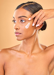 Image showing Face, skincare idea and woman with cream in studio isolated on a brown background. Dermatology, cosmetics and thinking Indian female model with lotion, beauty creme or moisturizer for skin health.