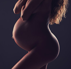 Image showing Art, stomach of pregnant woman and naked in studio with aesthetic dark background at maternity reveal. Creative pregnancy photoshoot, art and nude mother holding belly with healthy body and wellness.