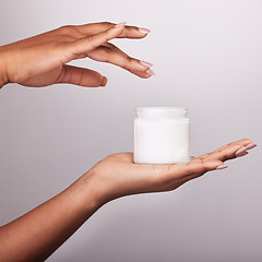 Image showing Woman, hands and moisturizer cream for skincare beauty, cosmetics or body care against a gray studio background. Hand of female holding cosmetic product, lotion or creme for moisturizing skin