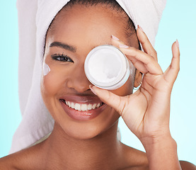 Image showing Black woman, jar and cream in studio portrait with smile for skincare, wellness or self care by blue background. Girl, african and model with product by eye for natural skin glow, beauty or cosmetics