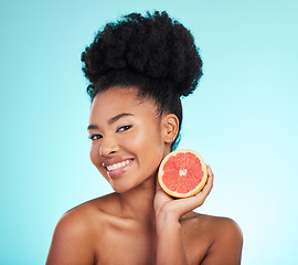 Image showing Grapefruit, skincare and woman portrait of beauty, wellness and detox healthcare. Isolated, blue background and studio with a young female feeling happy from healthy food with vitamin c for glow