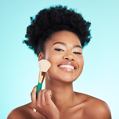 Image showing Black woman, brush and foundation in studio with smile for wellness, cosmetics or youth by blue background. Model, girl and african with makeup, powder and happy for skincare, beauty and healthy glow