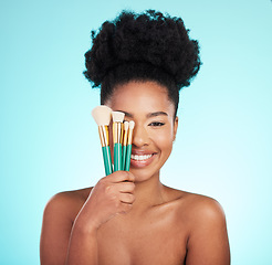 Image showing Makeup brushes, cosmetics and portrait of black woman for beauty, glamour and facial on blue background. Salon, cosmetology and face of happy girl for foundation, skincare and application in studio