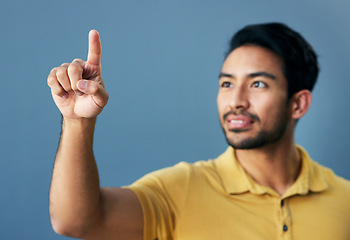 Image showing Finger, pointing and asian man with invisible hologram in studio with mockup against blue background. Interface, hand and creative male entrepreneur with advertising, marketing or idea while isolated