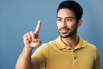 Image showing Pointing, finger and asian man with invisible hologram in studio with mockup against blue background. Interface, hand and creative male entrepreneur with advertising, marketing or idea while isolated