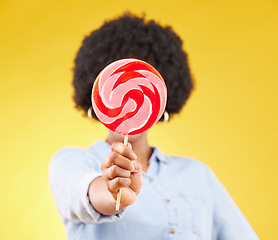 Image showing Cover, candy and lollipop with black woman in studio for colorful, cheerful and positive. Young, sweets and dessert with female isolated on yellow background for treats, food and confectionary