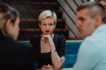 Image showing Happy businesspeople smiling cheerfully during a meeting in a coffee shop. Group of successful business professionals working as a team in a multicultural workplace.