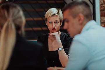 Image showing Happy businesspeople smiling cheerfully during a meeting in a coffee shop. Group of successful business professionals working as a team in a multicultural workplace.