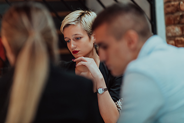 Image showing Happy businesspeople smiling cheerfully during a meeting in a coffee shop. Group of successful business professionals working as a team in a multicultural workplace.