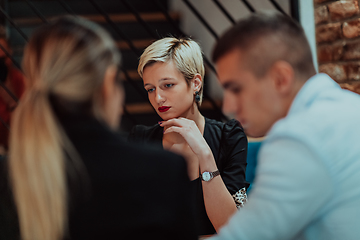 Image showing Happy businesspeople smiling cheerfully during a meeting in a coffee shop. Group of successful business professionals working as a team in a multicultural workplace.