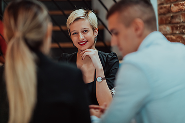 Image showing Happy businesspeople smiling cheerfully during a meeting in a coffee shop. Group of successful business professionals working as a team in a multicultural workplace.